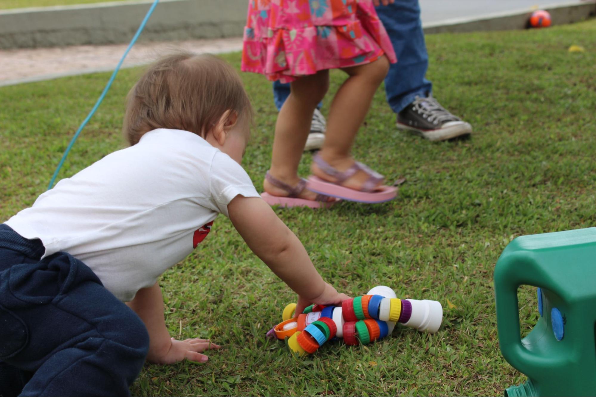 Bebê brinca com brinquedos educativos durante atividade infantil da Pastoral da Criança