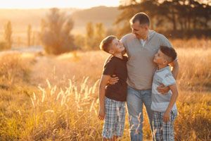 Pai com filhos no campo